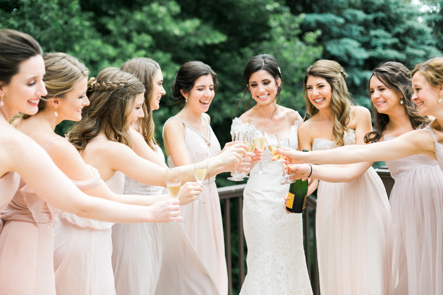 bride and bridesmaids with champagne cheers, discovery world summer lakeside elegant romantic wedding in milwaukee, wisconsin, photo by laurelyn savannah photography 8