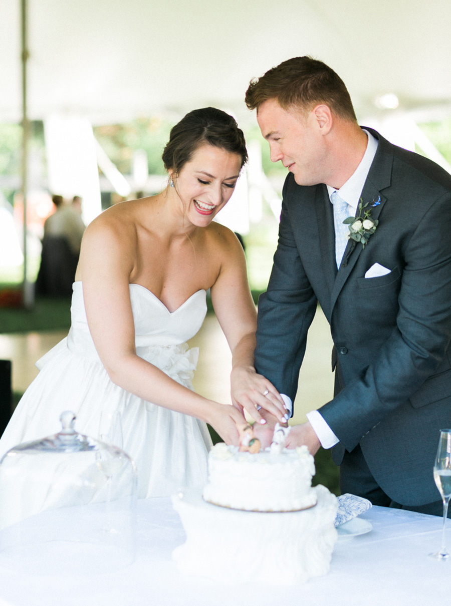cake cutting, outdoor tented private estate wedding in a field in wisconsin, gold and blue colors, photo by laurelyn savannah photography 30
