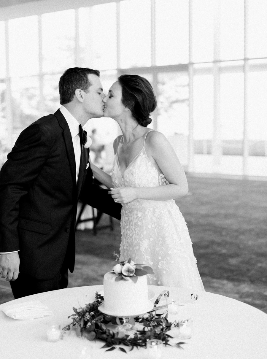 bride and groom cake cutting at Discovery World, elegant and modern lakefront wedding in downtown Milwaukee, Wisconsin with NYC flair, photo by Laurelyn Savannah Photography