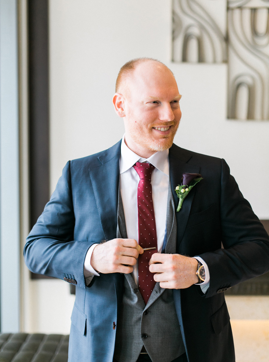 groom getting ready, romantic navy and gold and burgundy red fall wedding at Discovery World in downtown Milwaukee, Wisconsin, photo by Laurelyn Savannah Photography