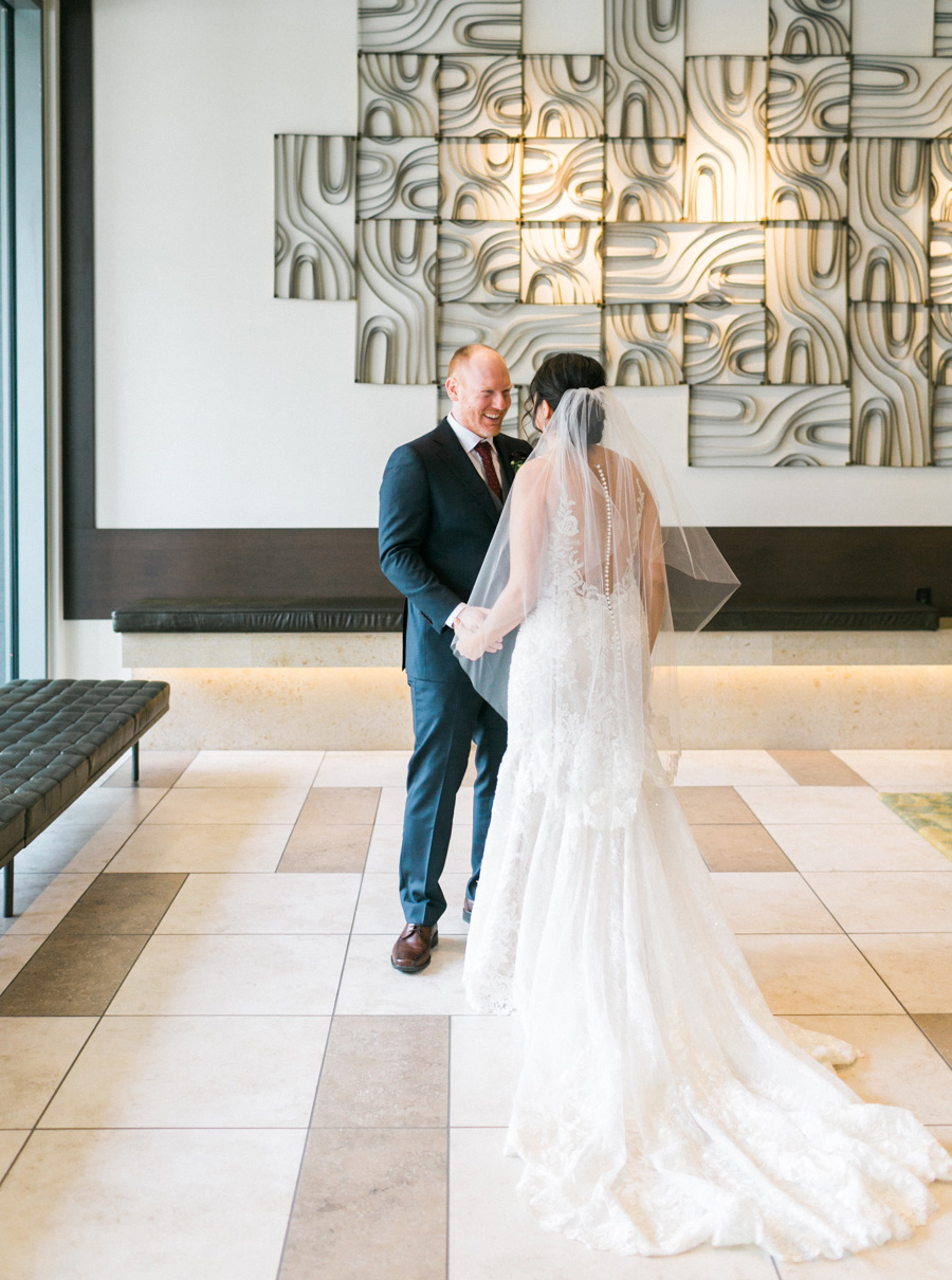 bride and groom first look, romantic navy and gold and burgundy red fall wedding at Discovery World in downtown Milwaukee, Wisconsin, photo by Laurelyn Savannah Photography