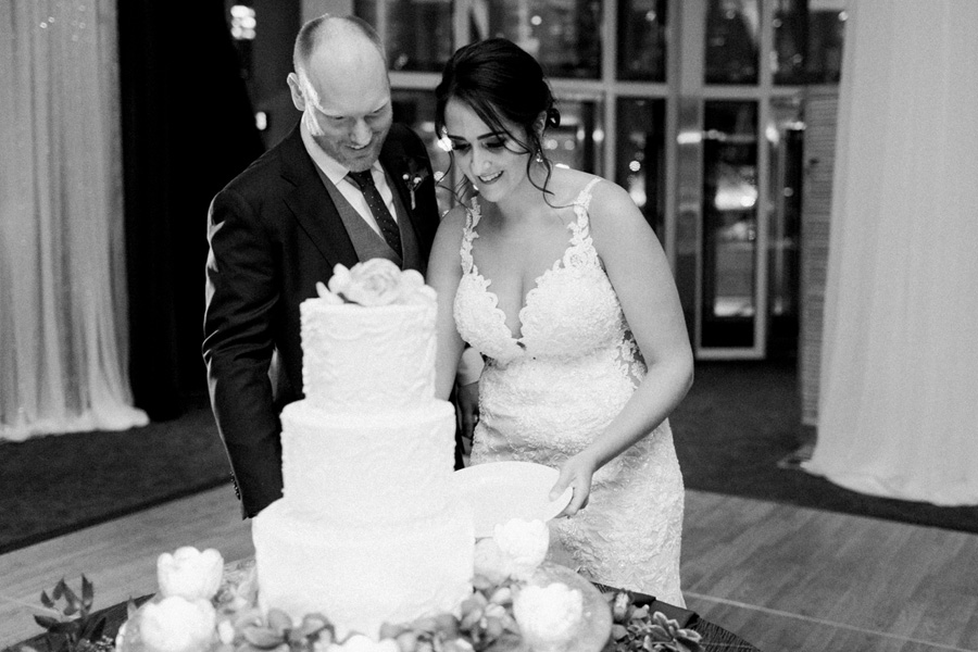 cake cutting, romantic navy and gold and burgundy red fall wedding at Discovery World in downtown Milwaukee, Wisconsin, photo by Laurelyn Savannah Photography