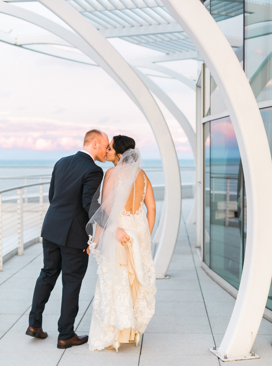 bride and groom sunset portrait, romantic navy and gold and burgundy red fall wedding at Discovery World in downtown Milwaukee, Wisconsin, photo by Laurelyn Savannah Photography