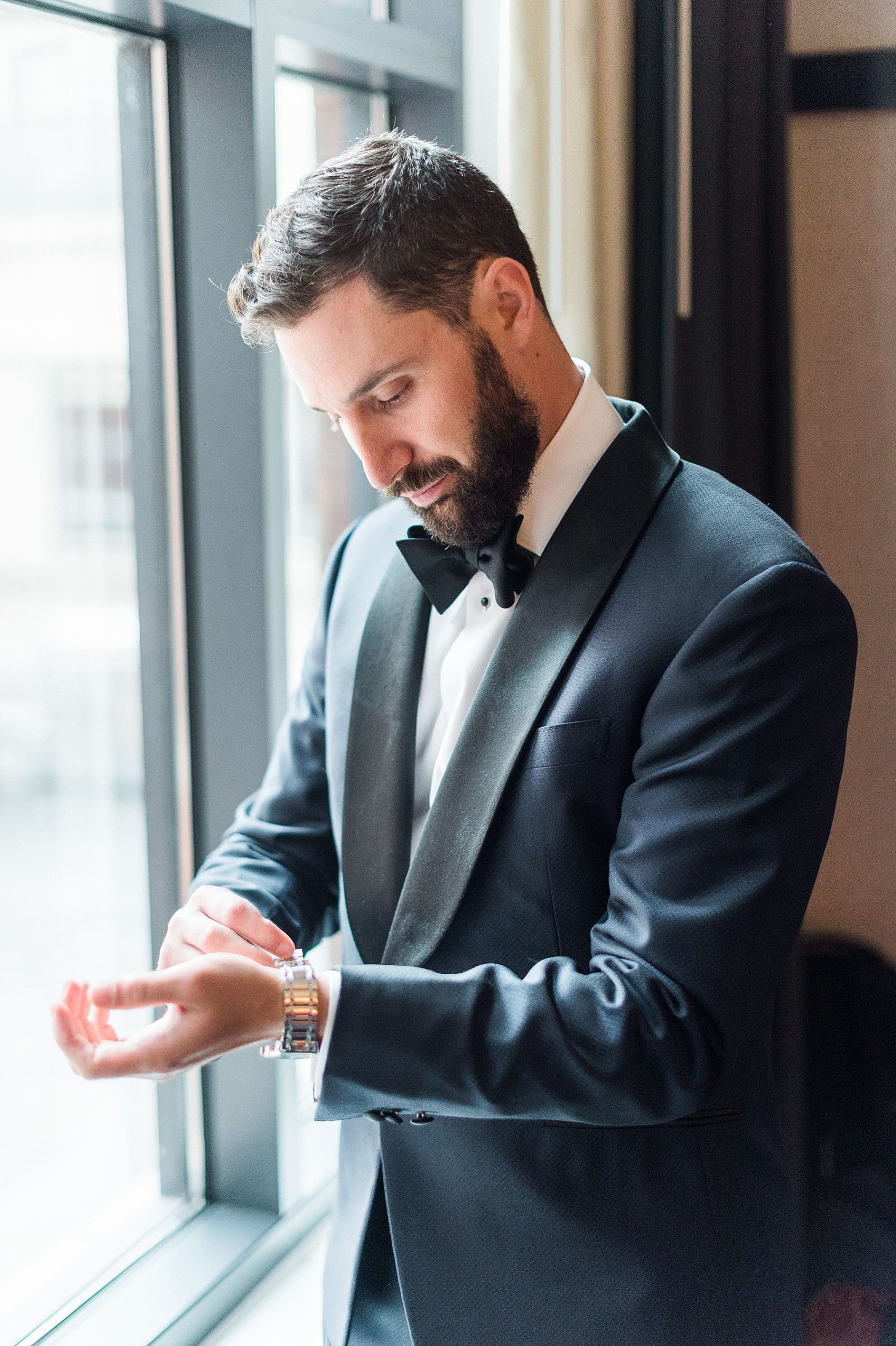 groom getting ready in charcoal black tux