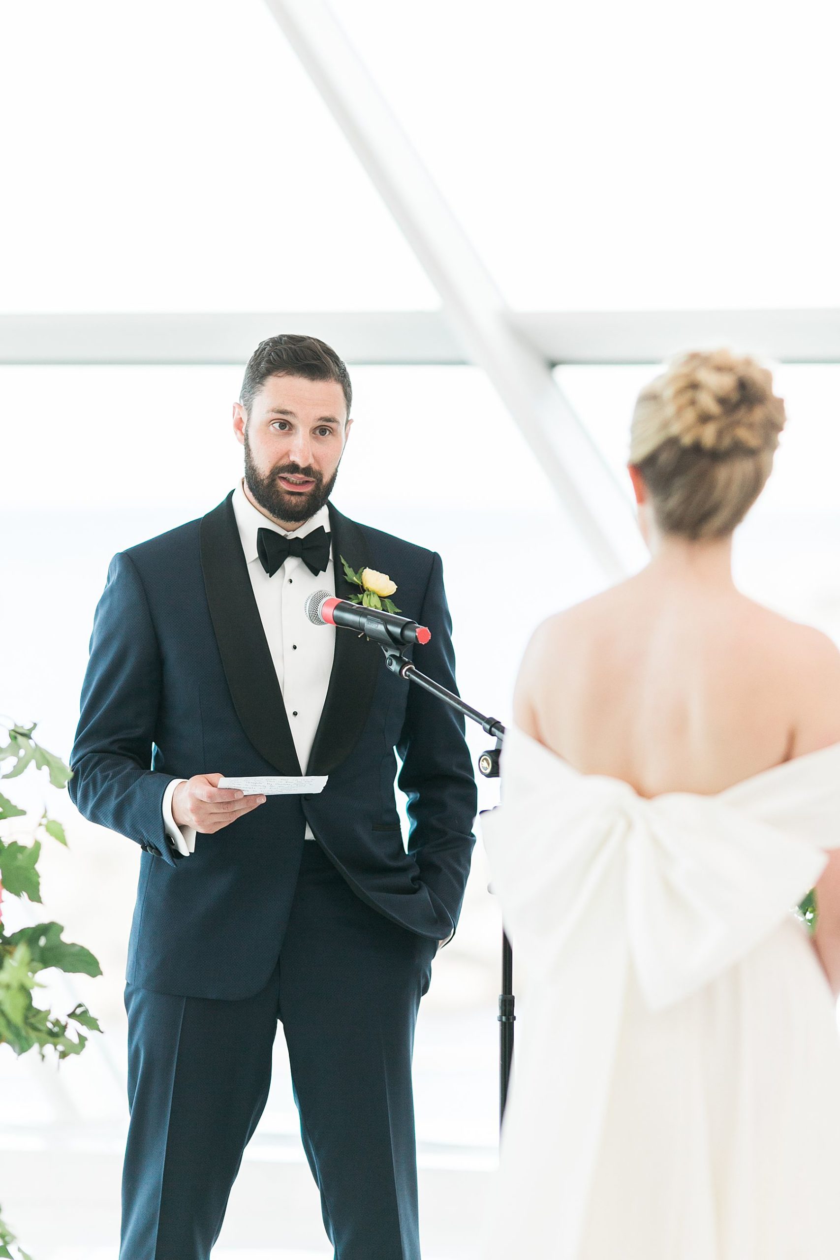 saying vows, modern minimal white and bright wedding ceremony at milwaukee art museum an architectural gem downtown with lake michigan view