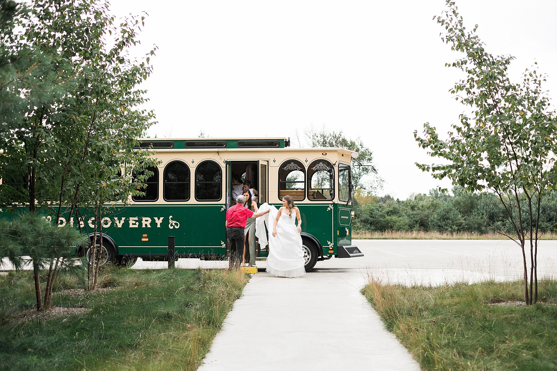 bride getting off trolley for wedding ceremony at straits chapel in kohler wisconsin