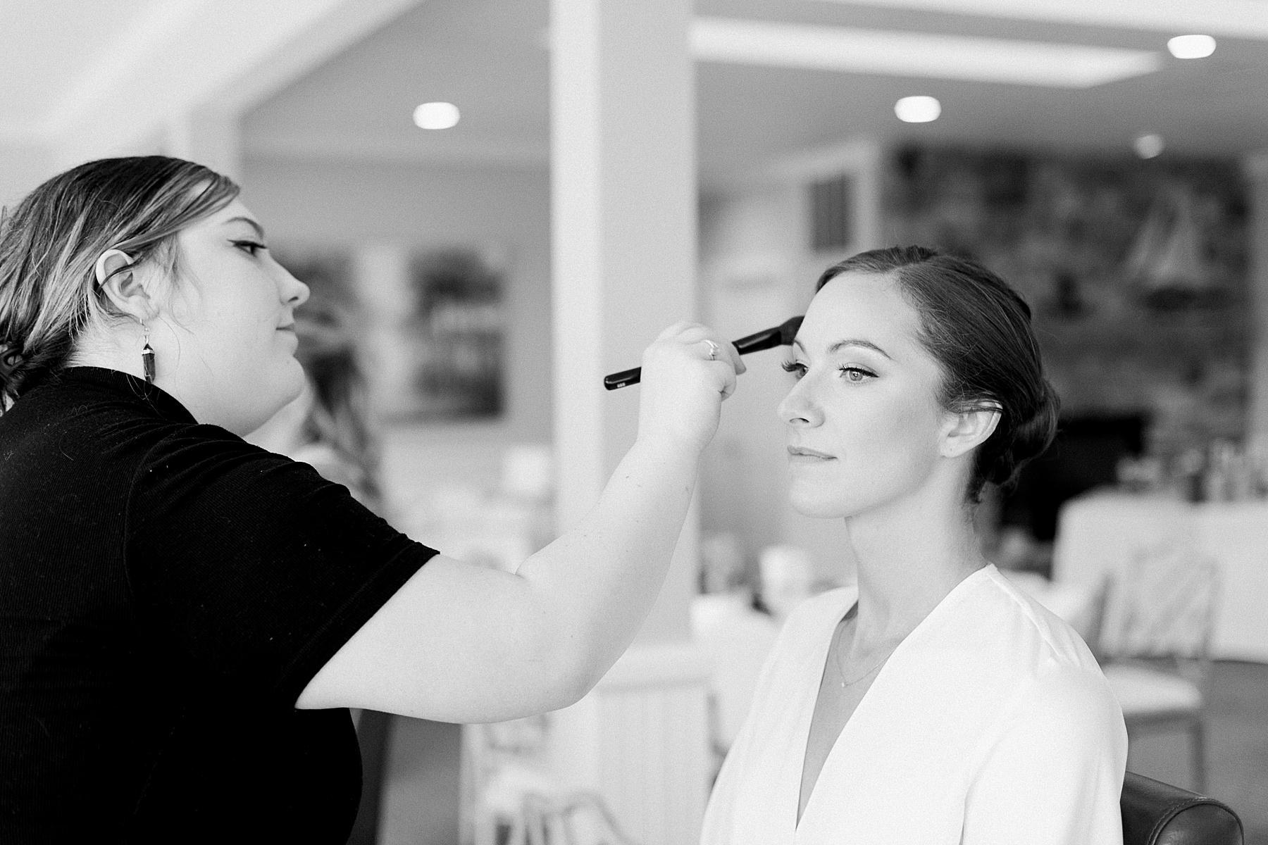 bride getting ready and getting her makeup done on wedding day