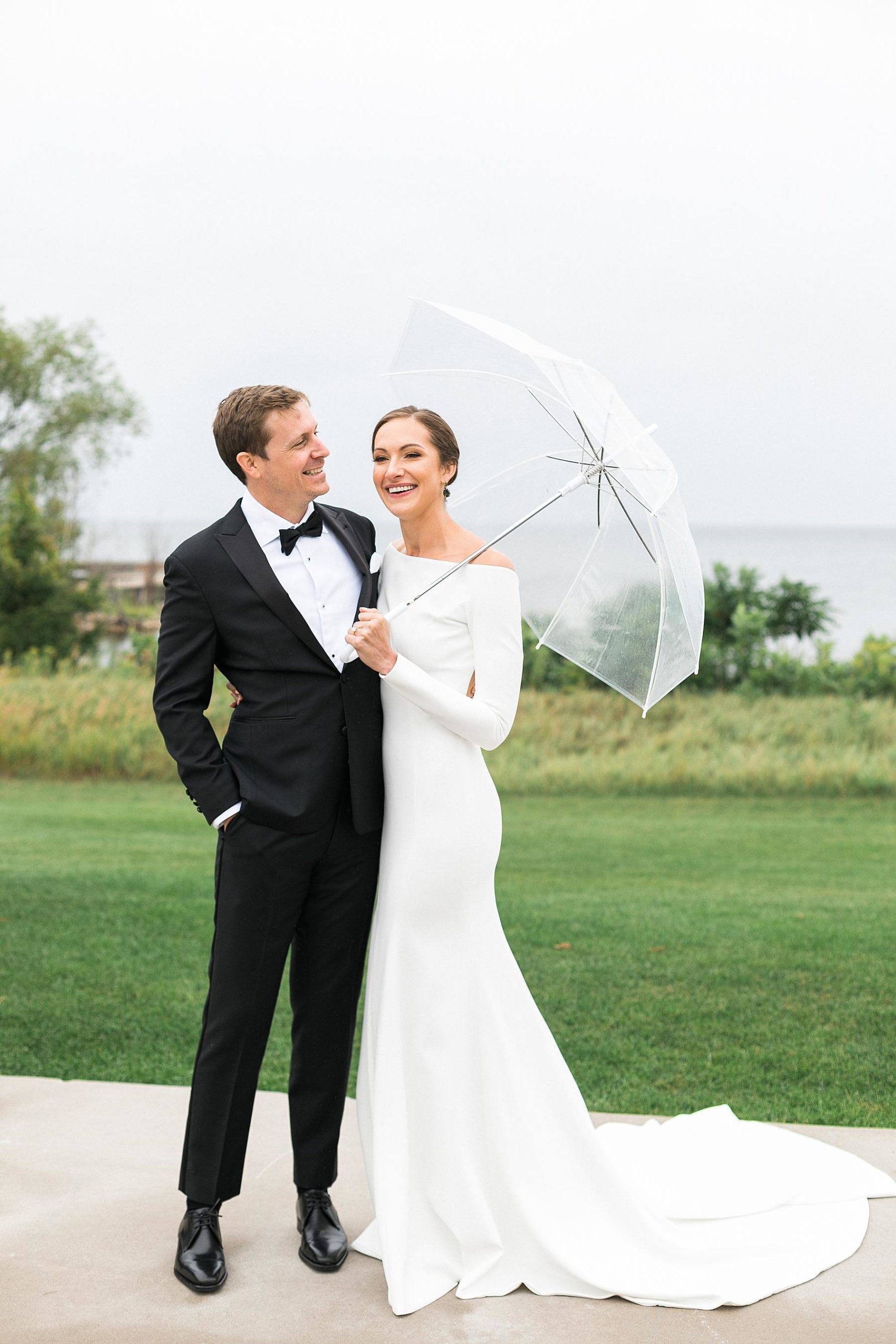 bride and groom newlywed portrait on a rainy day at horseshoe bay beach club in door county overlooking lake michigan in wisconsin