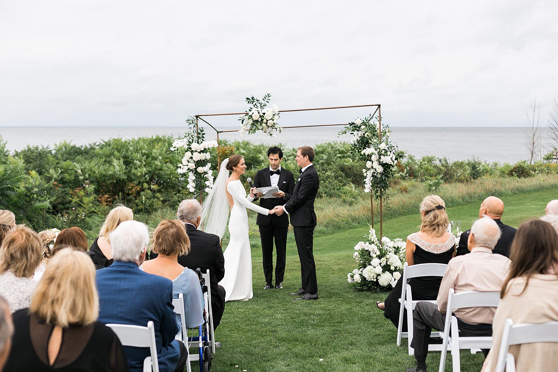 wedding ceremony at horseshoe bay beach club in door county, outdoors overlooking lake michigan in wisconsin