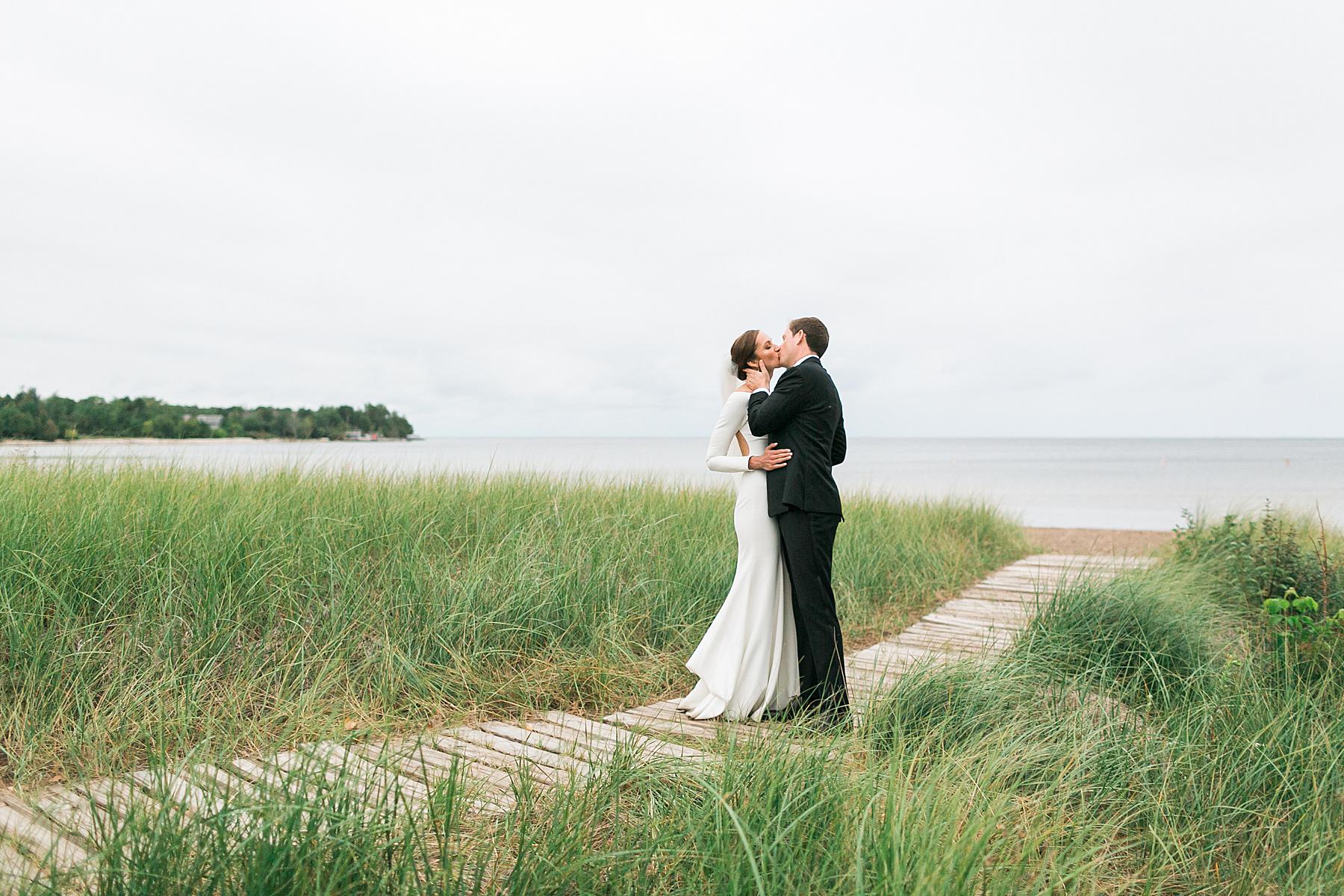 bride and groom newlywed portrait on a rainy day at horseshoe bay beach club in door county overlooking lake michigan in wisconsin