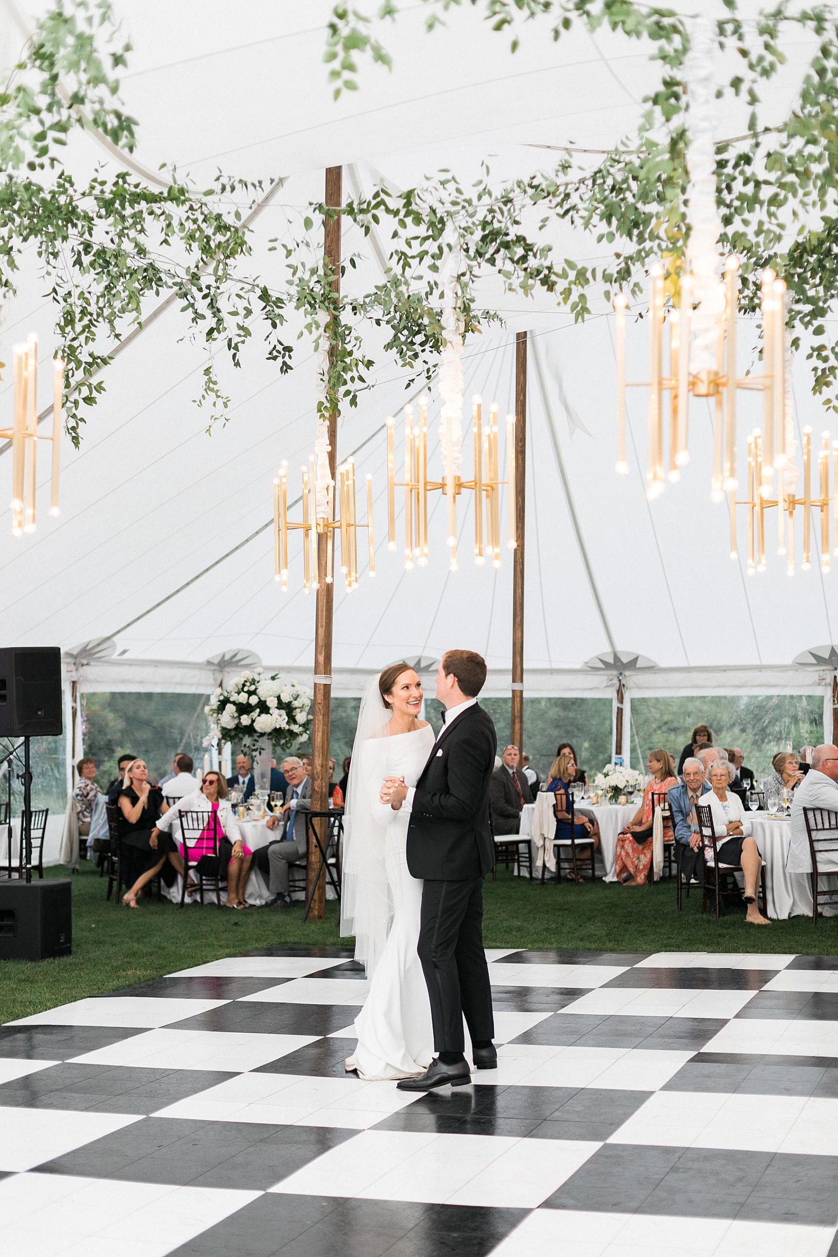 newlyweds first dance on checkerboard dance floor under a sailcloth tent wedding reception, at horseshoe bay beach club in door county