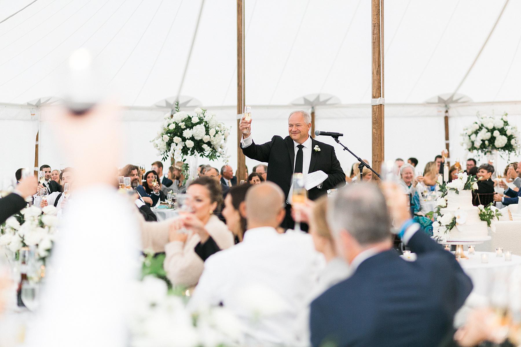 speech toast to newlyweds in a tented wedding reception, at horseshoe bay beach club in door county