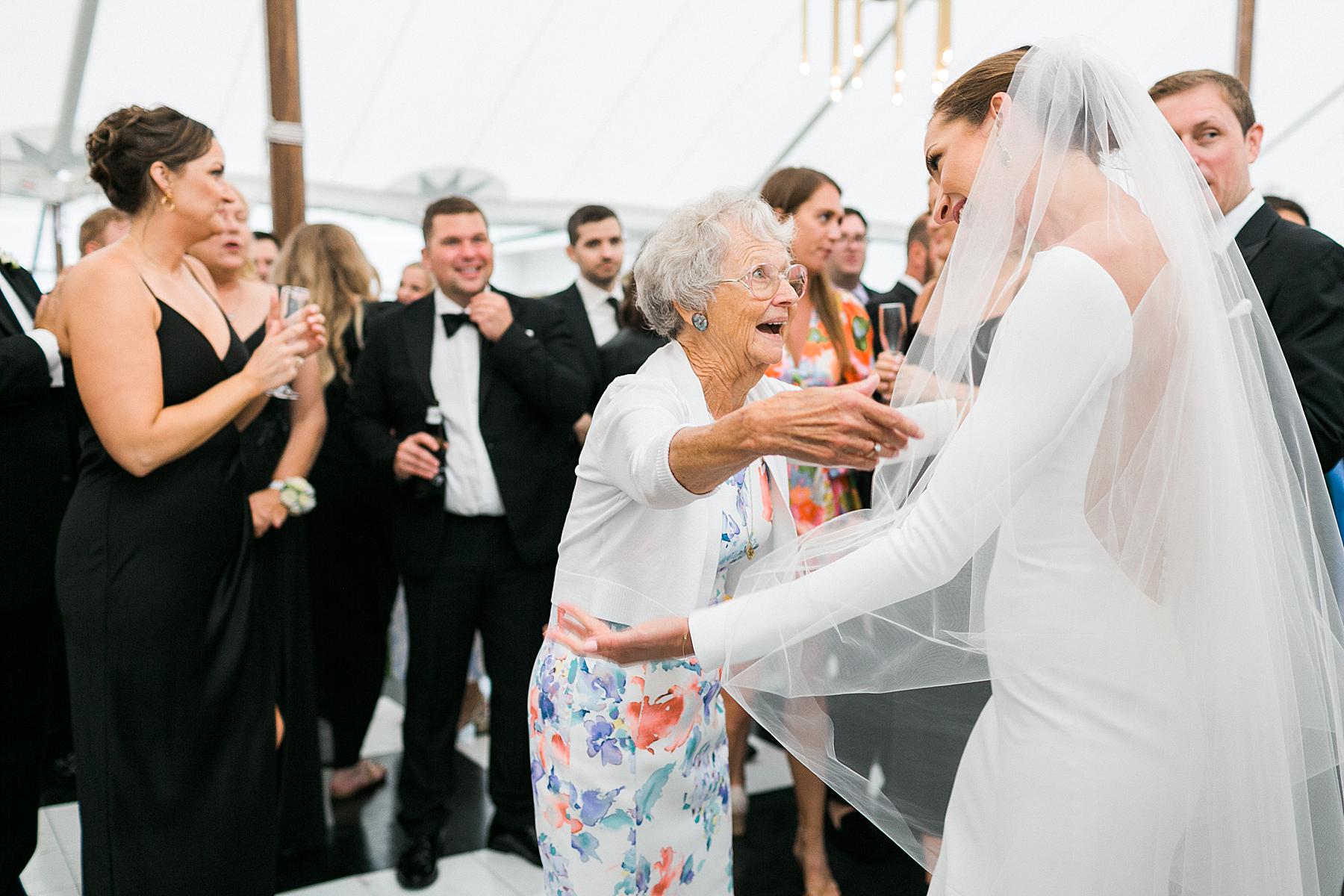 newlyweds dance with grandparents on checkerboard dance floor under a sailcloth tent wedding reception, at horseshoe bay beach club in door county
