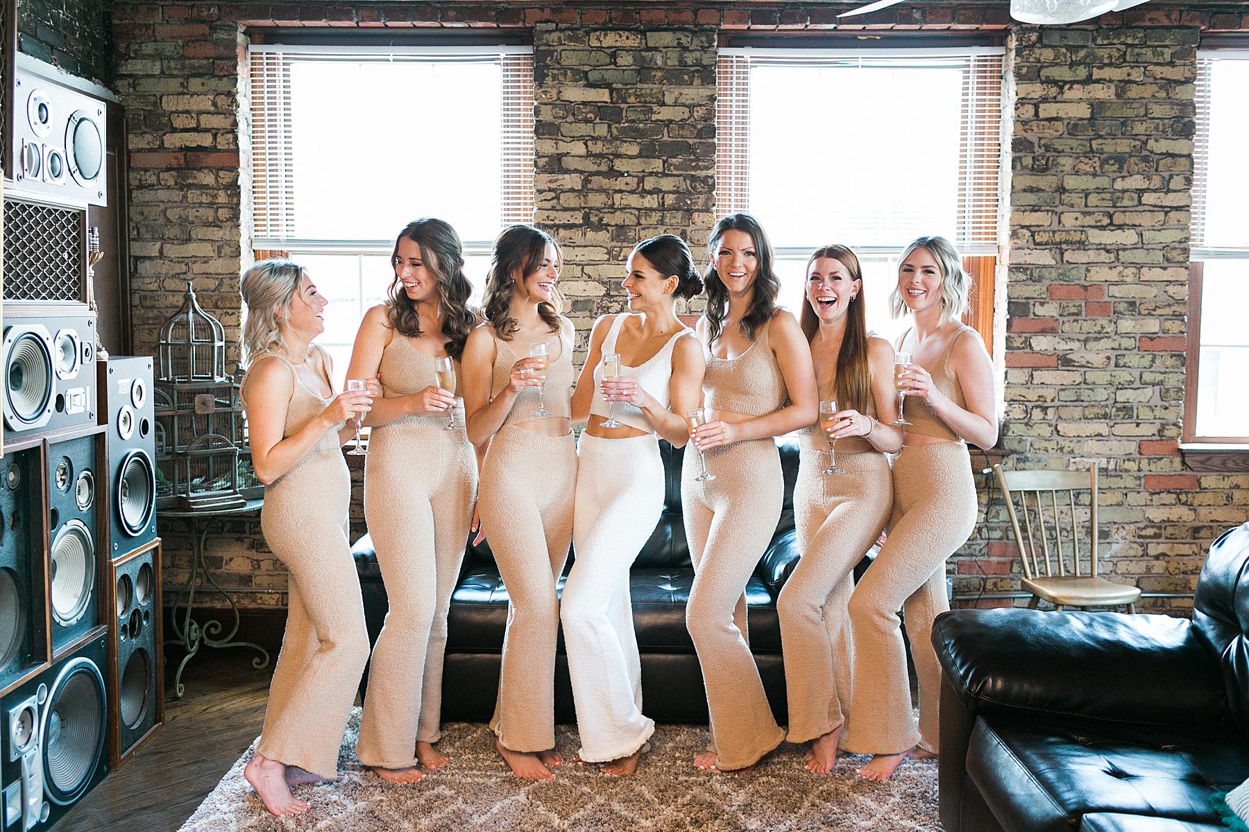 bride and bridesmaids champagne toast during getting ready prep time on wedding day