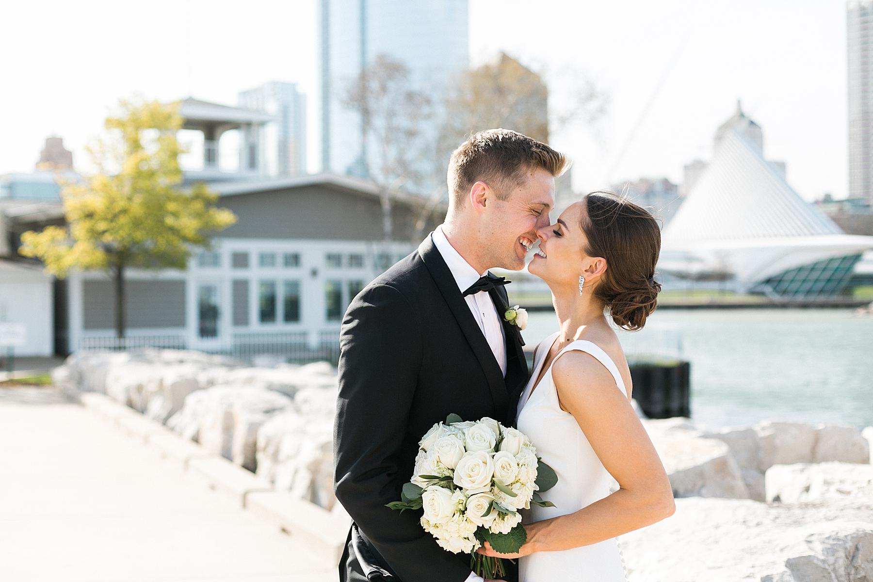 bride and groom couple newlywed portraits along the lakefront art museum and city skyline in downtown milwaukee, wi