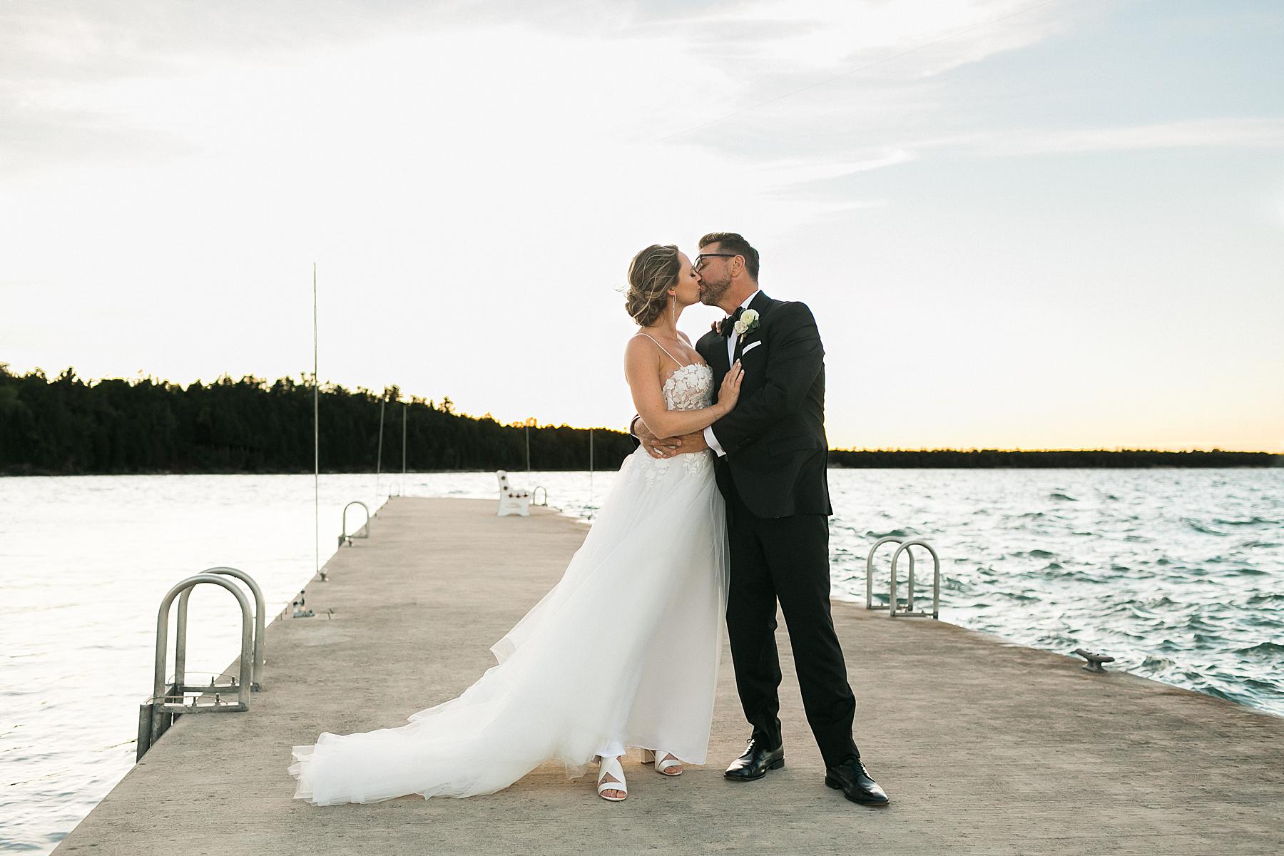 couples portrait on lakefront lake michigan pier on wedding day at gordon lodge in baileys harbor door county