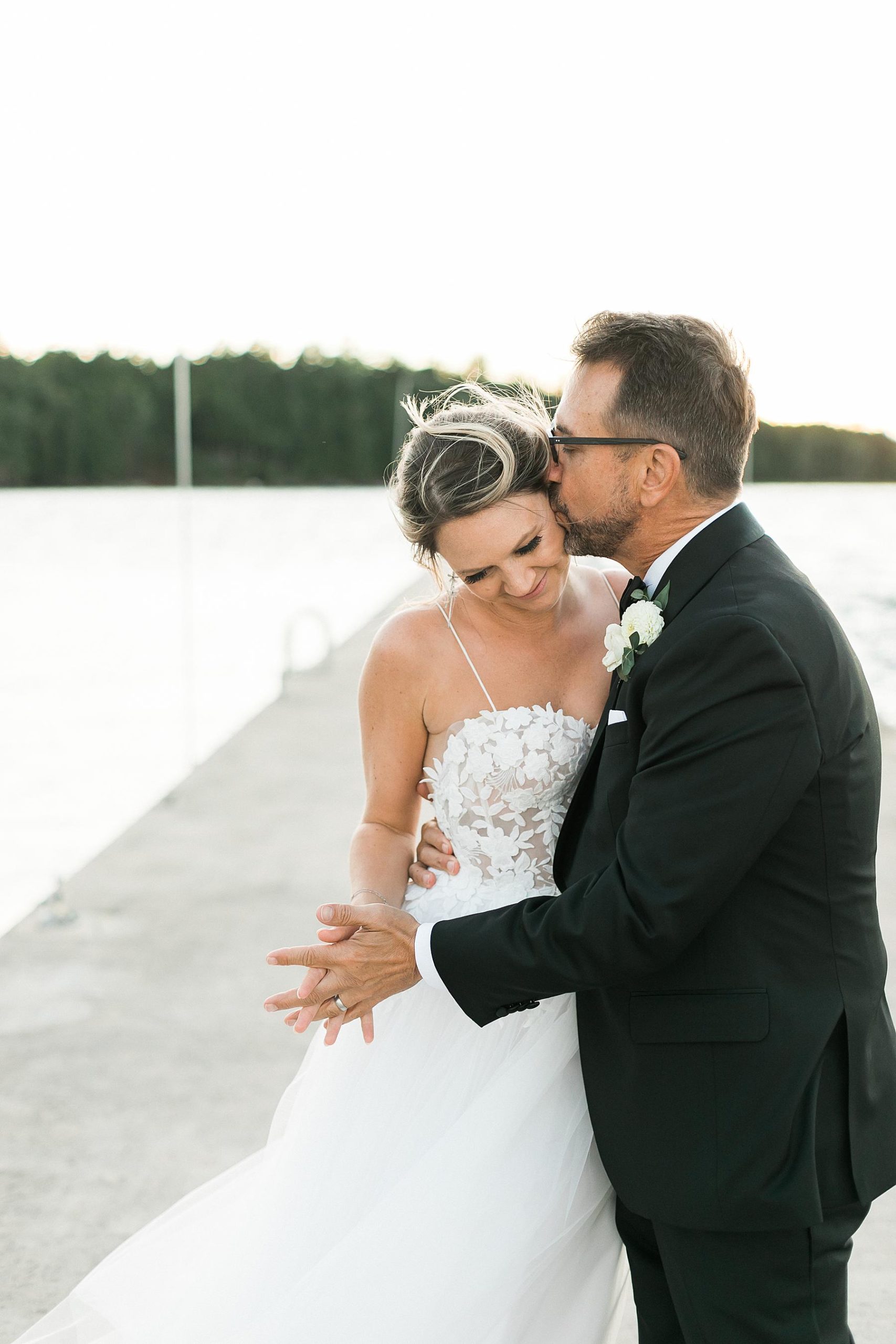 couples portrait on lakefront lake michigan pier on wedding day at gordon lodge in baileys harbor door county