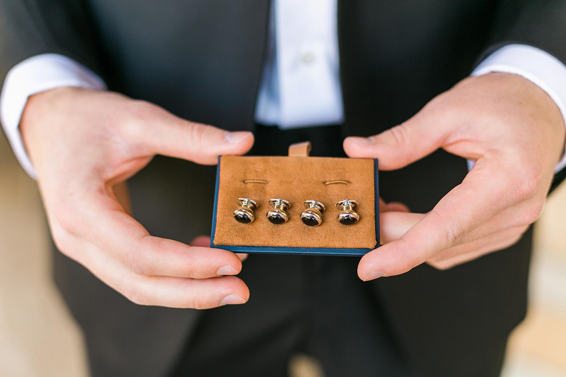 groom holding a box with cufflinks