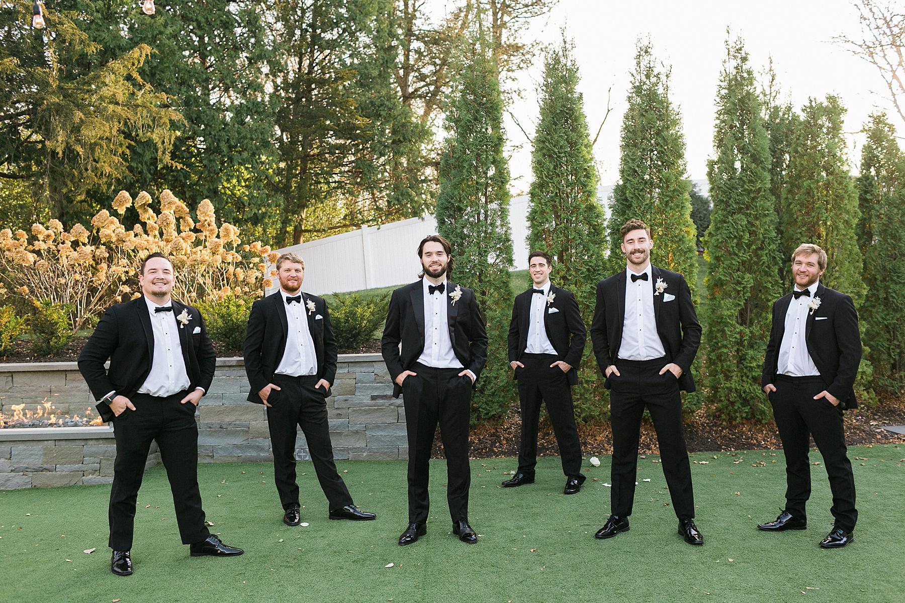 groom and groomsmen in black suits at hutton house in minneapolis minnesota