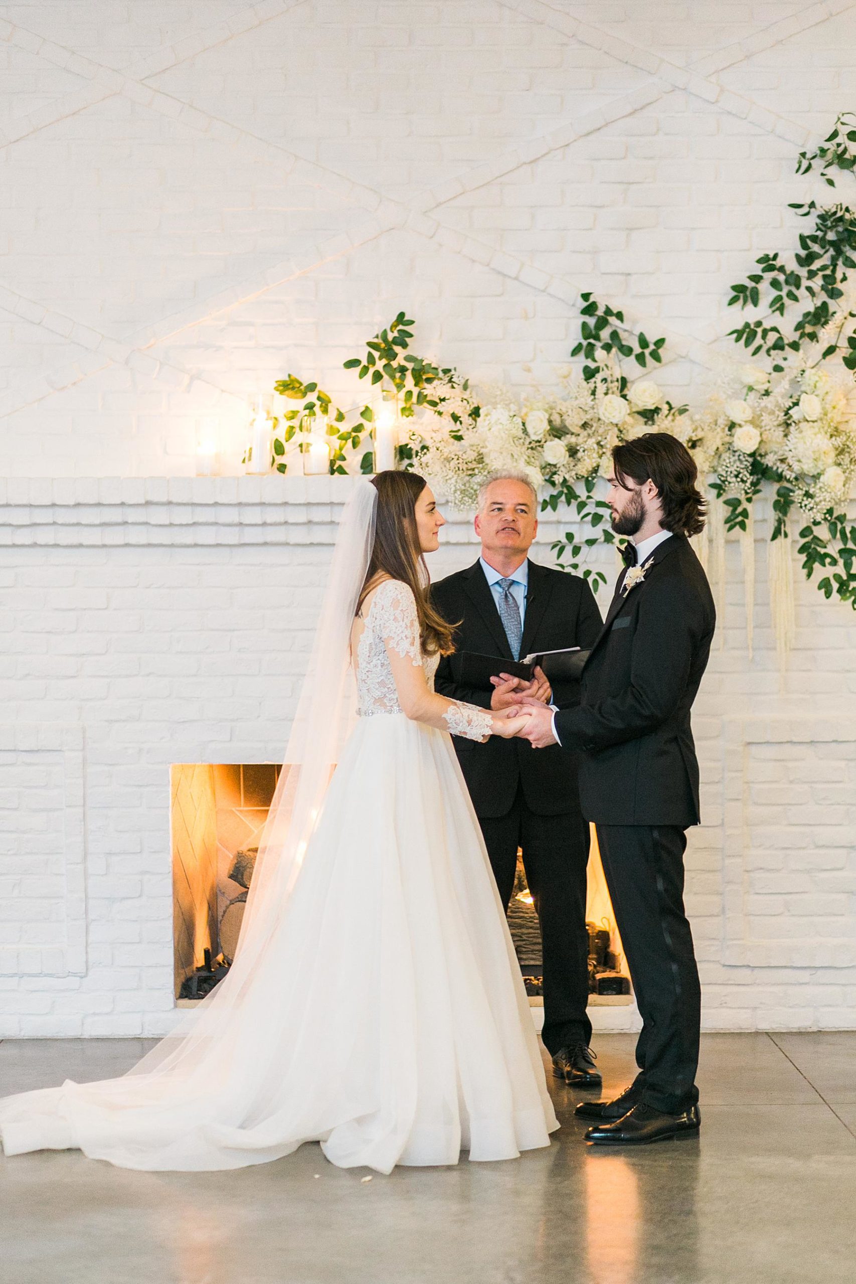 wedding ceremony in front of white fireplace at hutton house wedding venue in minneapolis minnesota