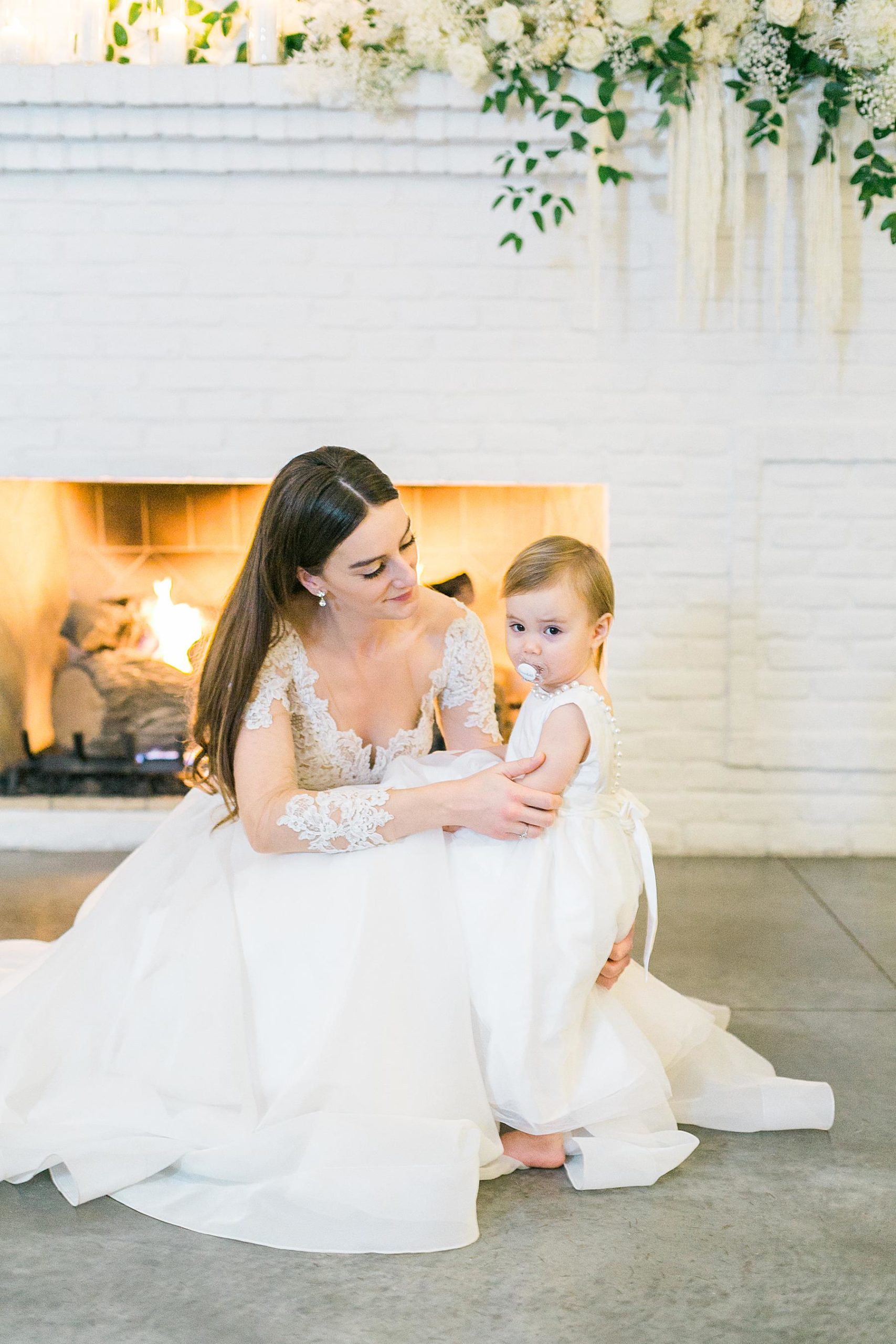 bride with flower girl in front of fireplace at hutton house wedding venue