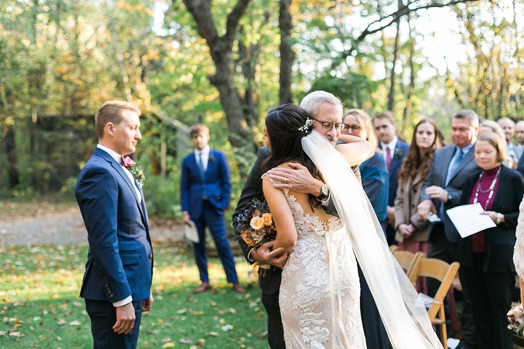 fall outdoor wedding ceremony at schlitz audubon nature center in milwaukee, wi