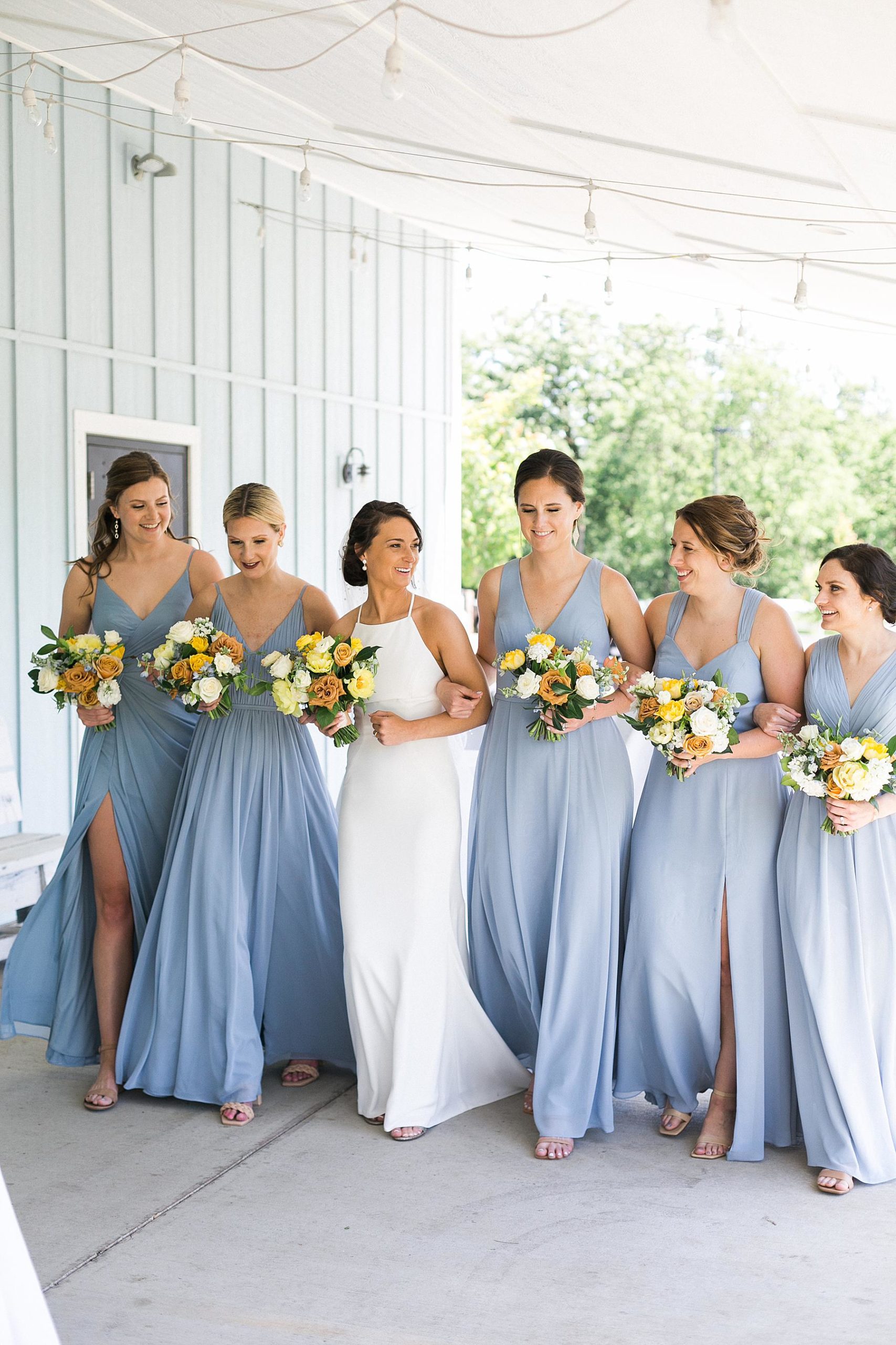 bride and bridesmaid bouquets in yellow, white, and orange, wearing blue dresses, fields reserve near madison, wisconsin