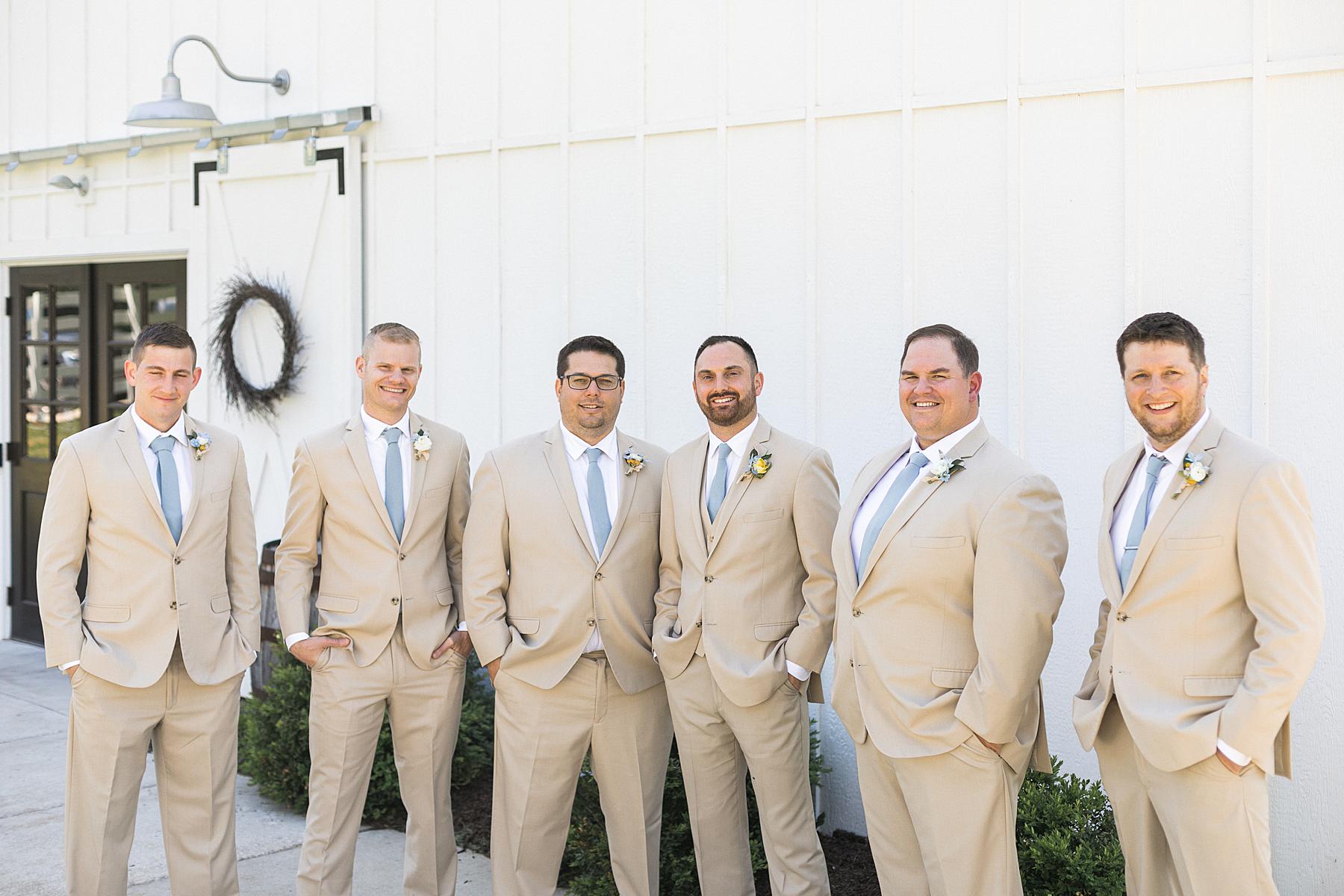 groom and groomsmen portrait photo in front of white barn, fields reserve near madison, wisconsin
