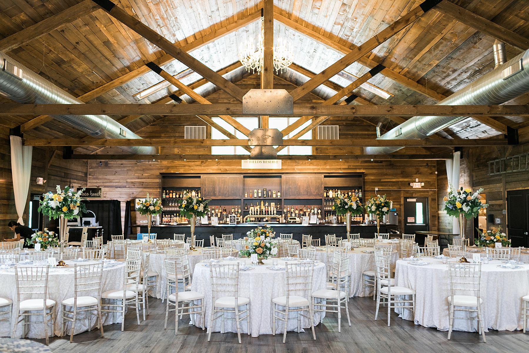 refined upscale barn wedding reception decor with yellow, orange, and blue florals fields reserve near madison, wisconsin