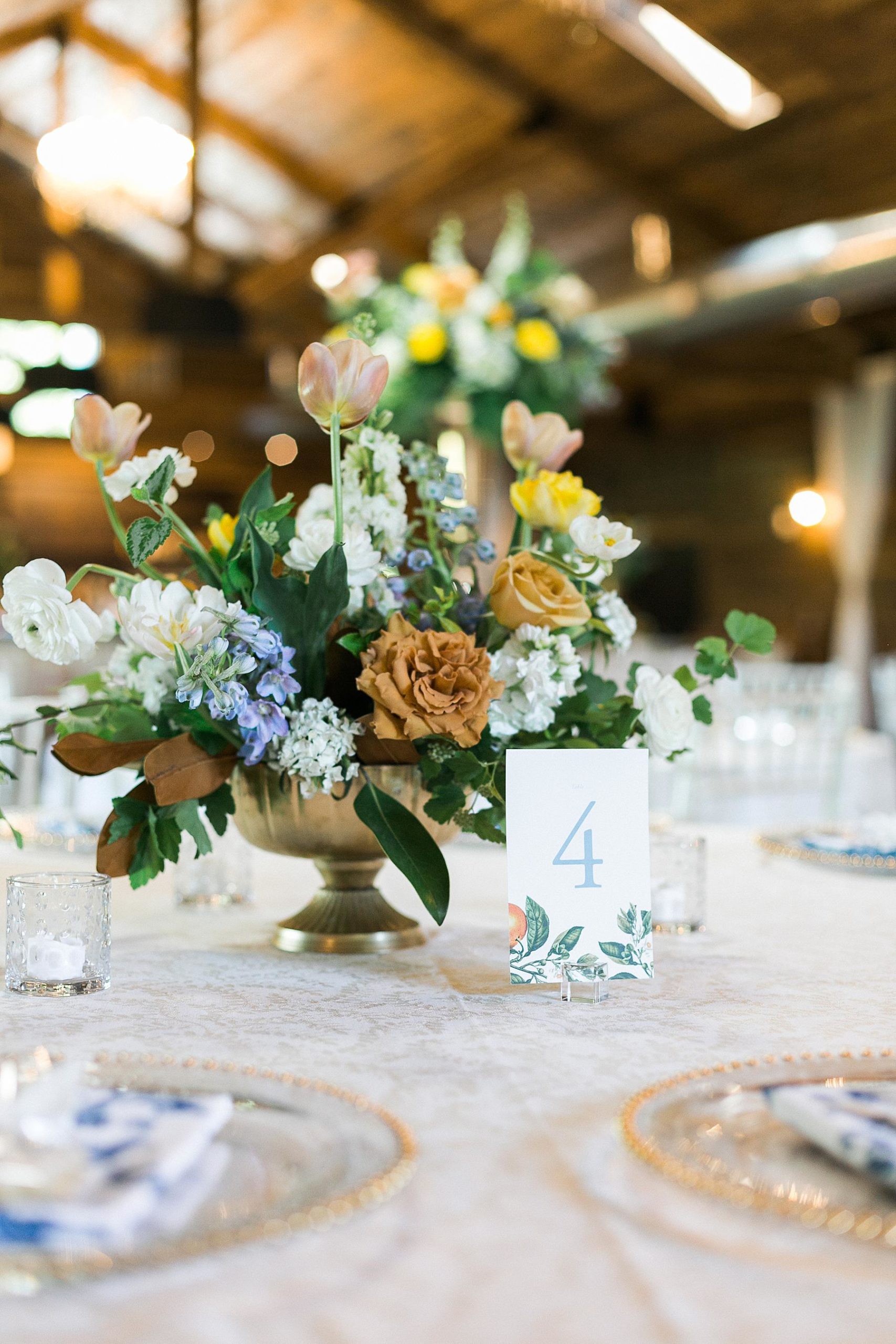refined upscale barn wedding reception decor with yellow, orange, and blue florals fields reserve near madison, wisconsin