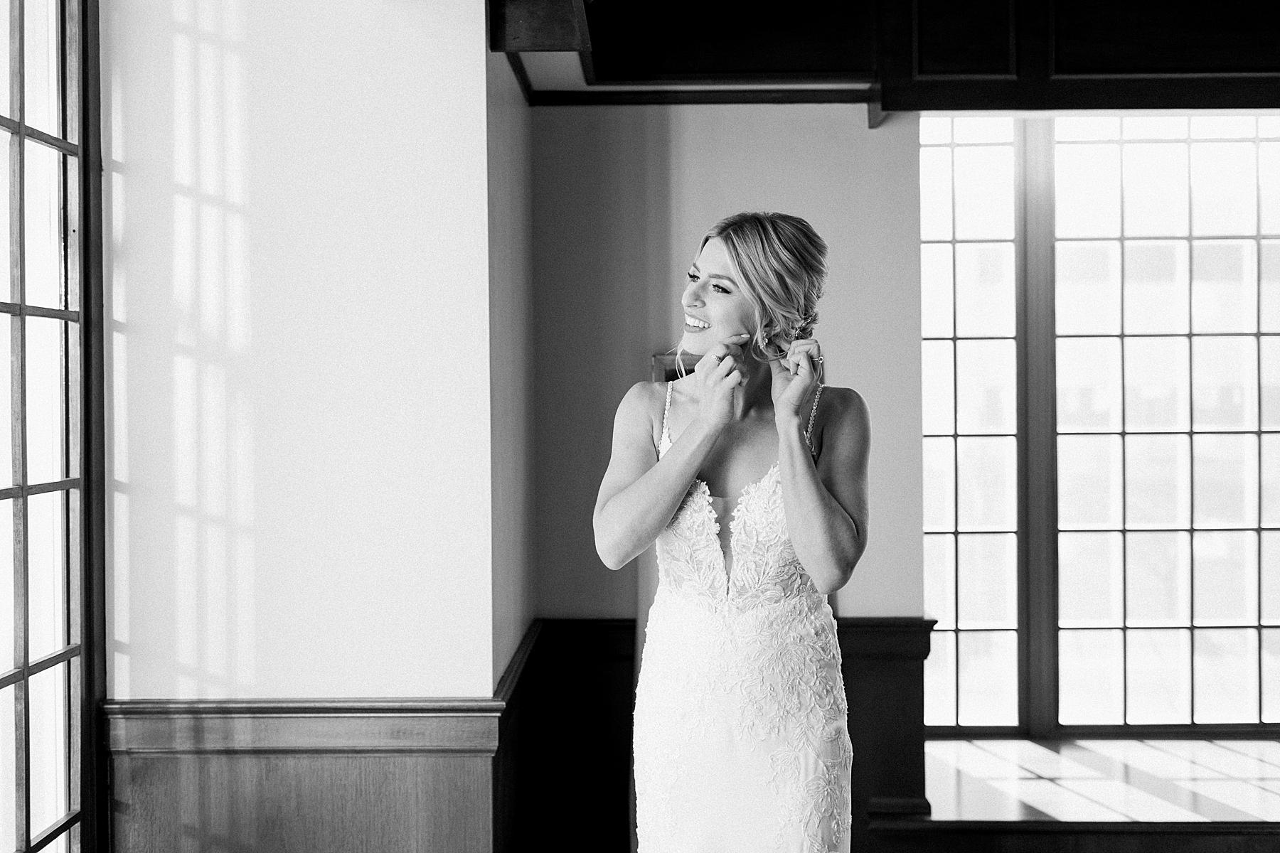 bride getting dressed in her lace wedding gown dress