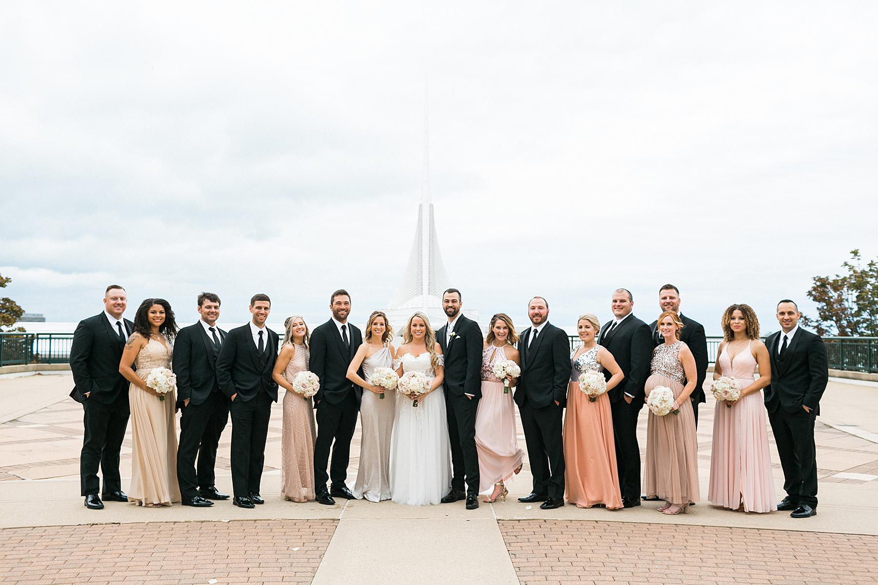 bridal party portaits photos in downtown milwaukee with art museum in the backgrund