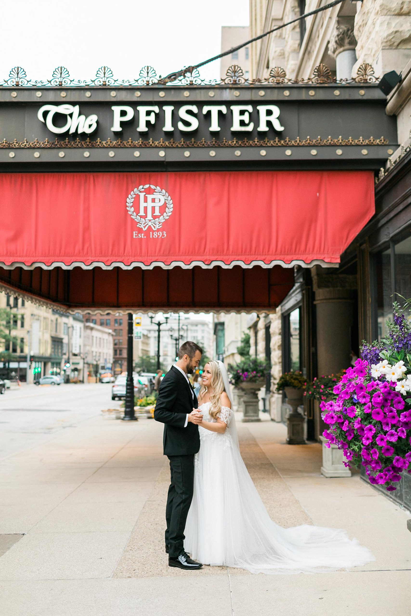 newlywed couple bride and groom portraits candid photos in downtown milwaukee, wisconsin in front of pfister hotel