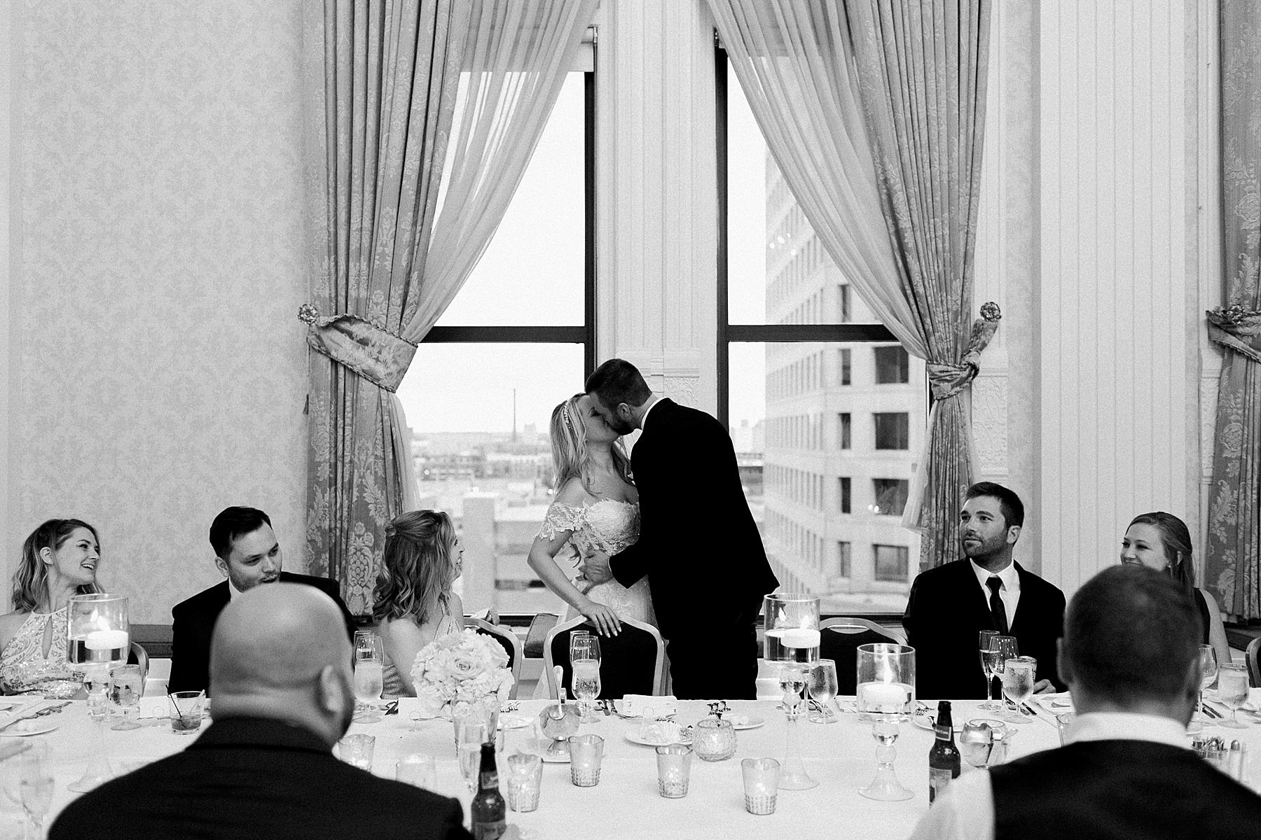 couple kissing at classic pfister hotel white and gold elegant milwaukee wedding reception