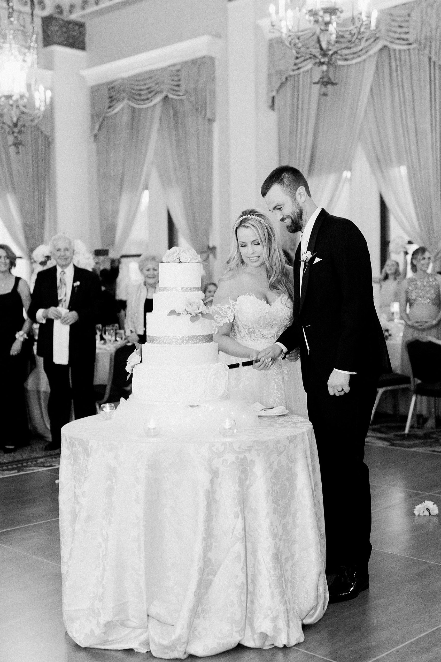 couple cutting cake at classic pfister hotel white and gold elegant milwaukee wedding reception