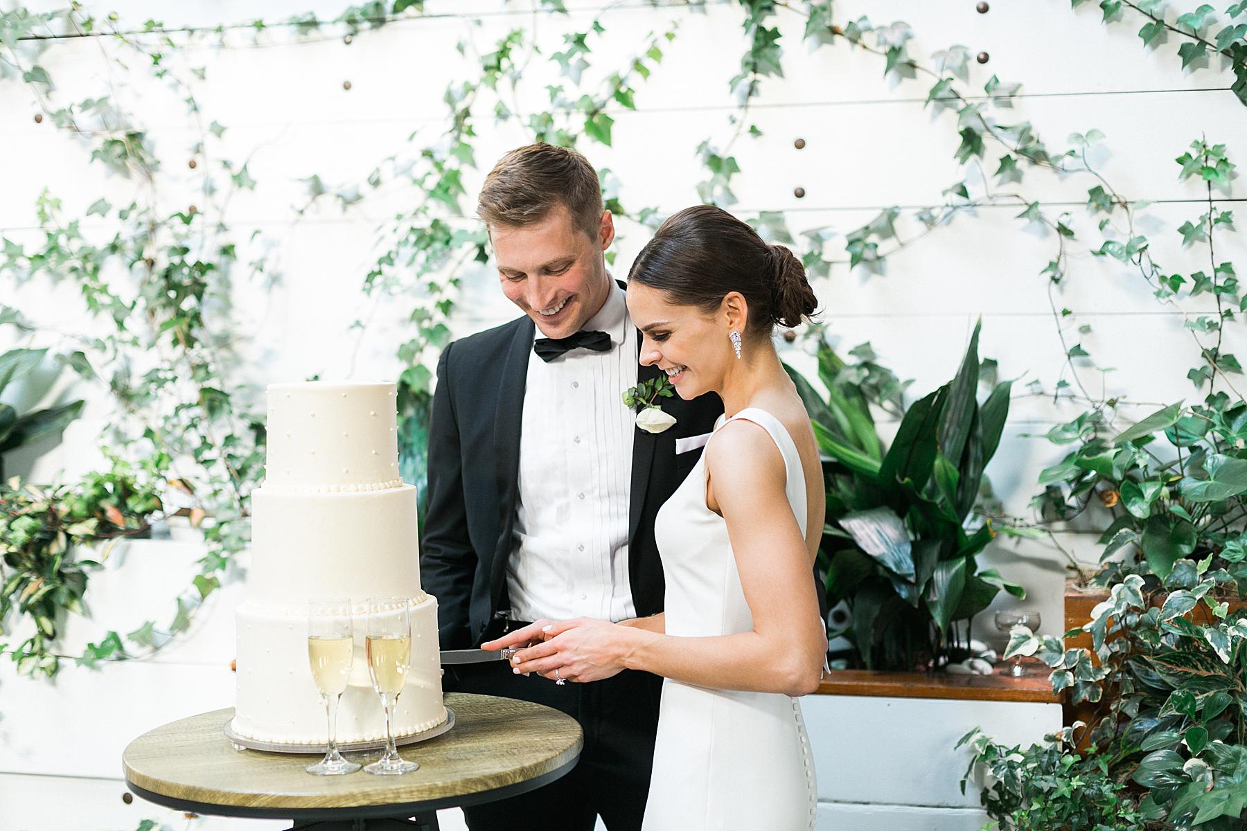 newlyweds cutting cake at wedding reception at ivy house, milwaukee, wisconsin